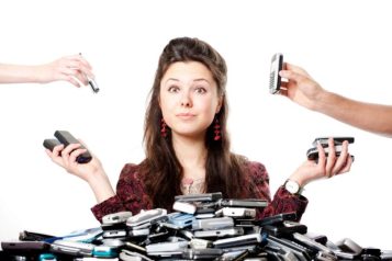Woman looking at the camera surrounded by a lot of mobile phones