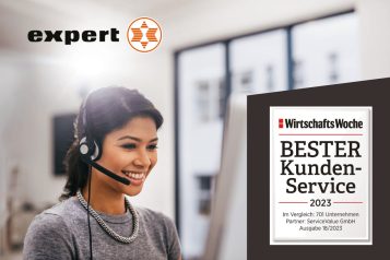 EXPERT-salesupply-1 Customer service representative with headset smiling at computer screen with Expert logo in top left corner