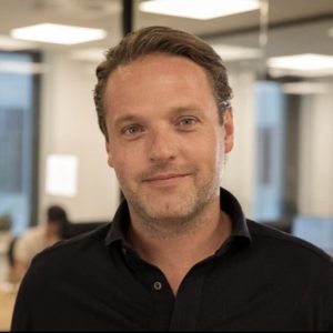 Man in black shirt smiling at camera